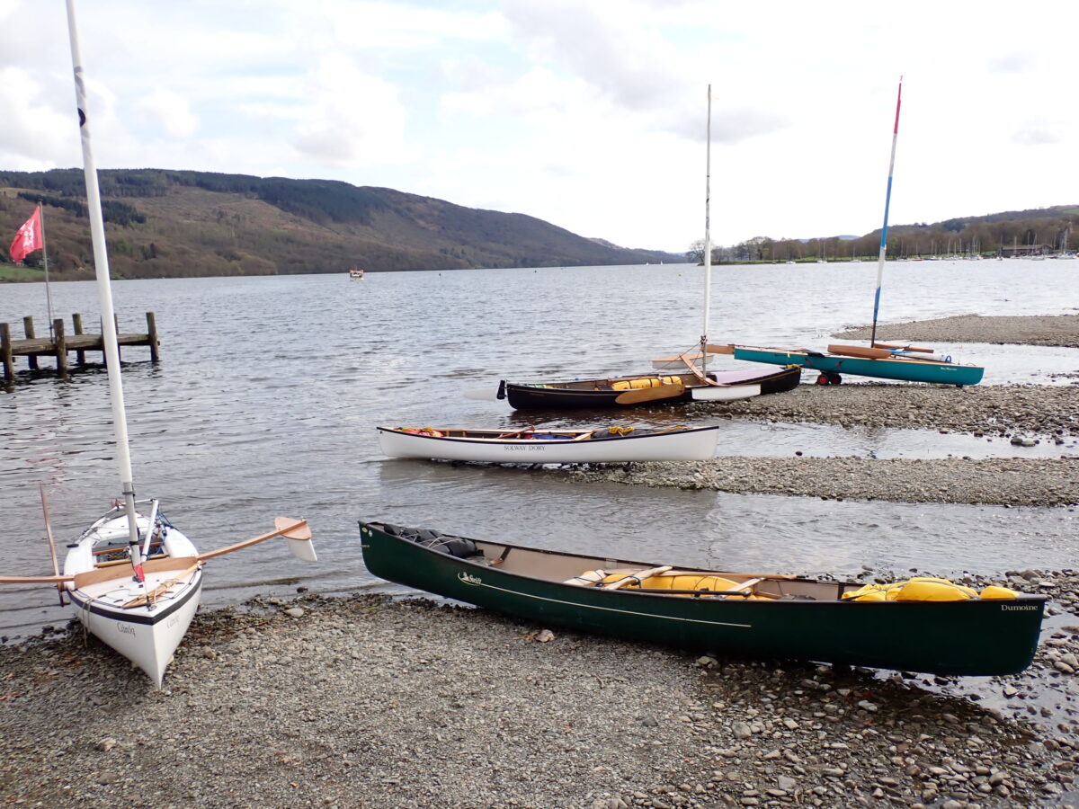 Sailing canoes beached while visiting the Bluebird café on Coniston Water