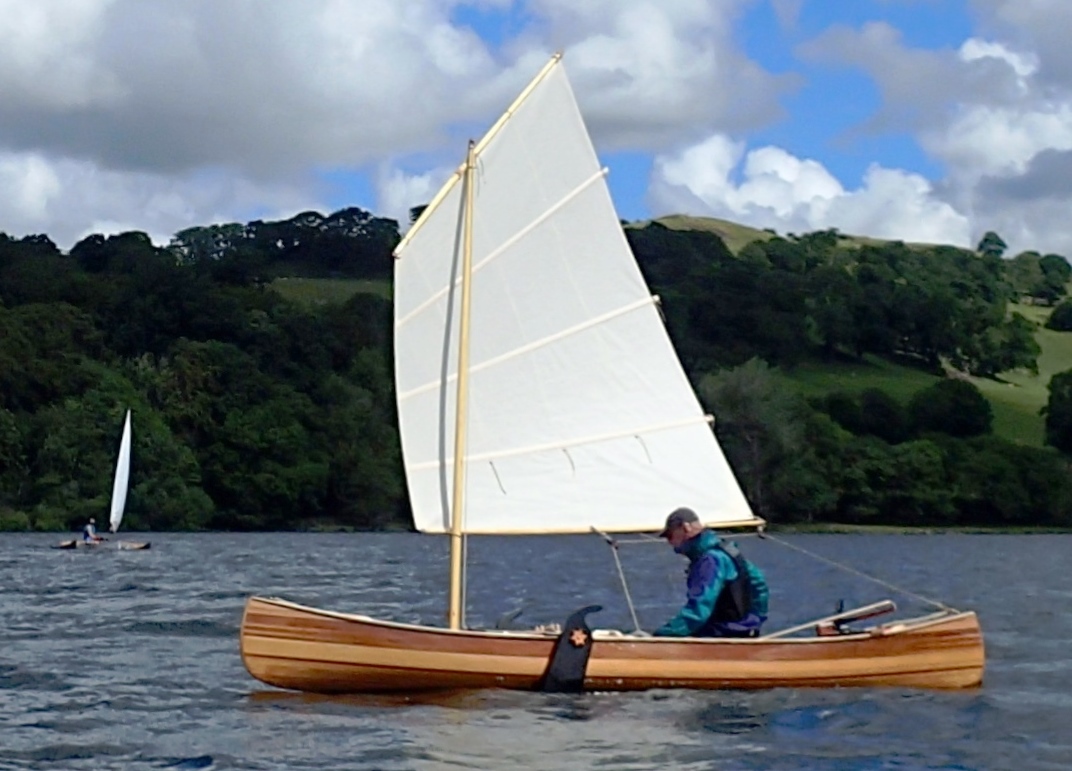 Wooden canoe with white sail